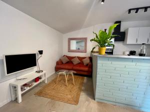 a living room with a red couch and a tv at Le Patio d’Eymet in Eymet