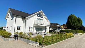 a white house with a black roof at Ferienwohnung mit Garten in Strasswalchen