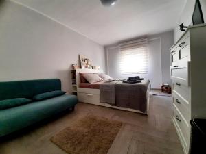 a bedroom with a bed and a couch and a window at Socrate Suite in Messina