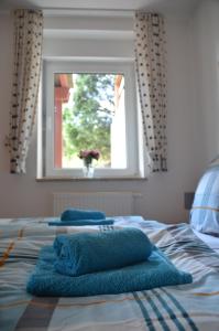 a bed with two towels on it with a window at Ferienwohnung Sonnenblume in Hohegeiß