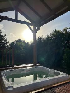 a hot tub sitting on top of a deck at Bungalow avec jacuzzi privatif in Sainte-Rose