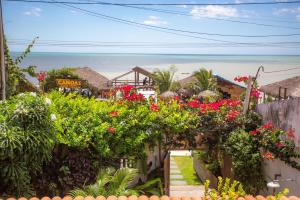 a garden with flowers and a view of the ocean at Pousada Jangada Prea in Prea