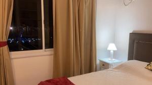 Dormitorio con ventana, cama y lámpara en Lo de ANNA en Posadas
