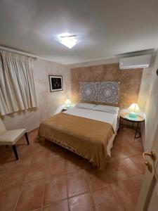 1 dormitorio con 1 cama y 2 mesas con lámparas en Villa Patrizia con piscina privata, en Stintino