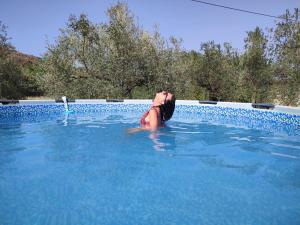 una mujer está en una piscina en El Cortijuelo de Zalea, en Málaga