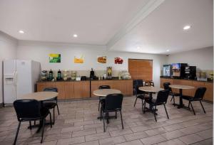 a restaurant with tables and chairs and a kitchen at Quality Inn Tallahassee near University in Tallahassee