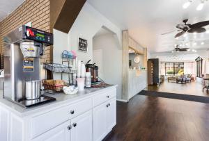 a kitchen with white cabinets and a living room at Econo Lodge Lebanon in Lebanon