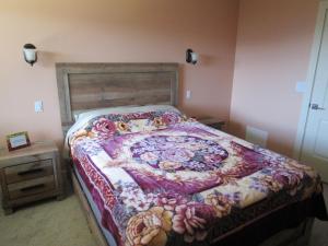 ein Schlafzimmer mit einem Bett mit einer Blumendecke darauf in der Unterkunft Okanagan Lake Sunrise BB in Vernon
