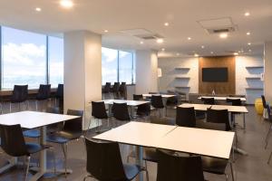 Comfort Inn Delicias في ديلسياس: قاعة اجتماعات مع طاولات وكراسي وتلفزيون