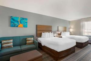 um quarto de hotel com duas camas e um sofá em MainStay Suites North - Central York em York