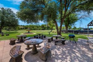 a patio with tables and chairs in a park at Suburban Studios in San Angelo