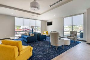 sala de estar con muebles amarillos y sofá azul en Comfort Inn & Suites New Port Richey Downtown District, en New Port Richey