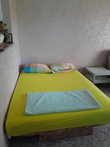 Cama verde en habitación con mesa en Studio Budva, en Budva