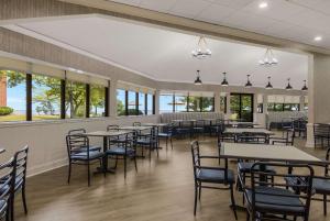 a dining room with tables and chairs and windows at The Inn on Maritime Bay, Ascend Hotel Collection in Manitowoc
