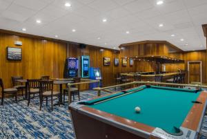 a pool table in a room with tables and chairs at The Inn on Maritime Bay, Ascend Hotel Collection in Manitowoc