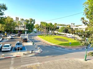 une rue de la ville avec des voitures garées sur la route dans l'établissement Luxury SeaSide DeShalit Square, à Herzliya