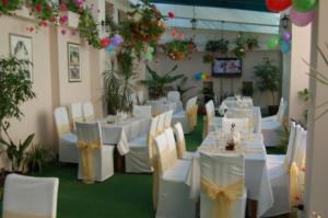 a banquet hall with white tables and chairs and flowers at Kniaz Boris Hotel in Sofia