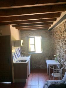 a kitchen with a sink and a table in a room at La Fontanina de Mario in Villaviciosa