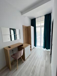 a room with a desk and a chair and a window at Infinity by Carla in Costinesti