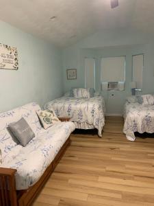 ein Zimmer mit 3 Betten und einem Sofa darin in der Unterkunft Cute Space Near Chicks Beach in Virginia Beach