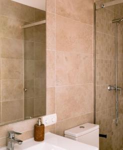 een badkamer met een toilet, een wastafel en een spiegel bij Villa KM2 lovely villa located just outside of Sa Carroca a 5 minute drive from Playa den Bossa in San Jose de sa Talaia