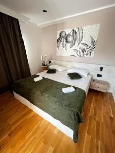 een slaapkamer met een groot bed en een schilderij aan de muur bij MEMORI bed&breakfast in Rab