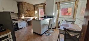 a kitchen with a counter and a table and chairs at A Casa de Meli in Muros