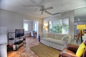 a living room with a white couch and a tv at Gulfside Resort Unit 2 in St. Pete Beach