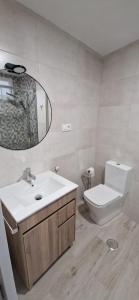 a bathroom with a toilet and a sink and a mirror at A Casa de Meli in Muros +8 photos