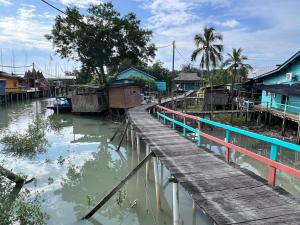 a village with a dock and houses on the water at 吉胆岛 潮汐民宿 Pulau Ketam Tide Homestay in Bagan Teochew