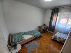 a bedroom with two beds and a desk and a window at Kuca za odmor "MARIJA" in Vrbovsko