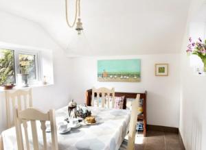a dining room with a white table and chairs at Middleway Cottage in Saint Blazey