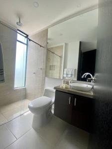 a bathroom with a toilet and a sink and a shower at Hermosa casa de campo con piscina Girardot flandes in Girardot