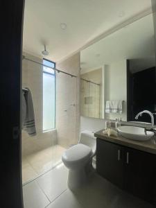 a bathroom with a toilet and a sink and a shower at Hermosa casa de campo con piscina Girardot flandes in Girardot