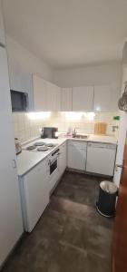 a kitchen with white appliances and a trash can at Apartment Panorama in Bad Reichenhall