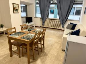 - un salon avec une table, des chaises et un canapé dans l'établissement Casa Domus del Chirurgo, à Rimini