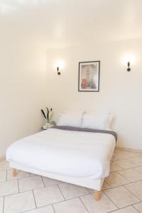 uma cama branca num quarto com uma parede branca em Grand T5 sur Créteil entre Paris et Disney em Créteil