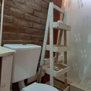 a wooden ladder next to a toilet in a bathroom at Cabañas Gemas del Lago in Potrero de los Funes