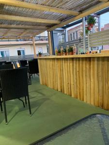 eine Terrasse mit einer Bar mit Tischen und Stühlen in der Unterkunft Hippie City Hostel in Chania