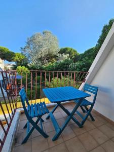 - une table de pique-nique bleue et 2 chaises sur le balcon dans l'établissement Studio Cabine Clim Wifi Parking Draps - 1 étoile - self check-in possible, à La Grande Motte