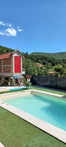 a swimming pool in front of a house at Casa do Loureiro in Paradela