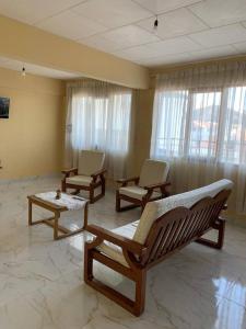 a room with three rocking chairs and windows at Ultimo piso c/ terraza centrico in Cochabamba