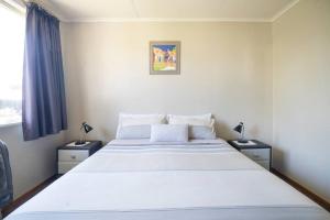 een slaapkamer met een groot wit bed en 2 nachtkastjes bij Turangi Home Family Size in Taupo