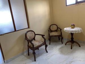 een kamer met 2 stoelen en een tafel en een tafel met een tafel. bij Ultimo piso c/ terraza centrico in Cochabamba