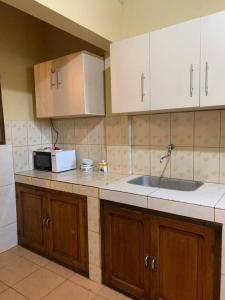 a kitchen with a sink and a microwave at Ultimo piso c/ terraza centrico in Cochabamba