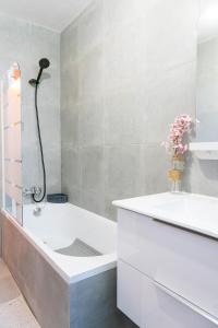uma casa de banho com uma banheira e um lavatório em Grand T5 sur Créteil entre Paris et Disney em Créteil