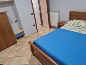 - une chambre dotée d'un lit bleu et de carrelage dans l'établissement La Rustica House, à Ortona