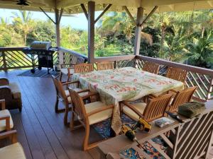 a table and chairs on a porch with a grill at THE HONOMU HOUSE - Gorgeous, Spacious 4Bd2Ba Home near Waterfalls and Hilo, Sleeps 12! in Honomu