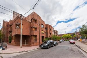 un edificio de ladrillo rojo con coches aparcados en la calle en Santa Cruz 316 - B Alto Alberdi enfrente al Nuevo Centro Shopping en Córdoba