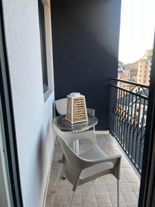 a table and a chair on a balcony at La Montaña apartman in Zlatibor